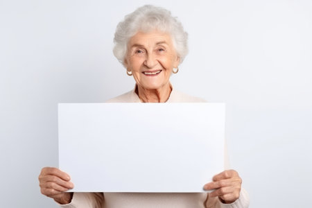 Happy old woman holding blank white banner sign, isolated studio portraitの素材