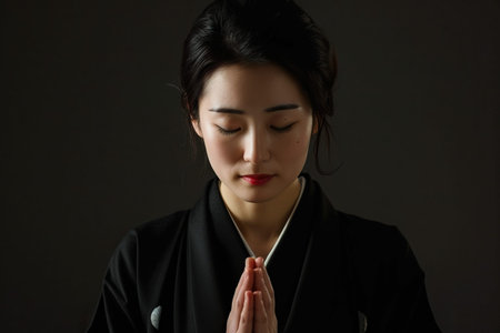 Japanese woman prays to god on black studio backgroundの素材