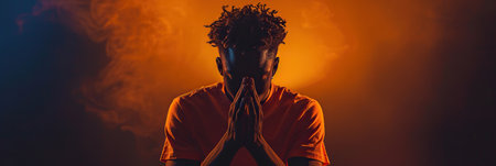 African American Man prays to god on black studio backgroundの素材