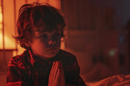 Caucasian boy prays to god in dark children room. Cinematic effectの素材