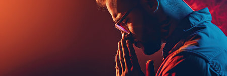 Man prays to god on dark studio background. Cinematic effectの素材