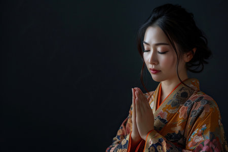 Japanese woman prays to god on black studio backgroundの素材