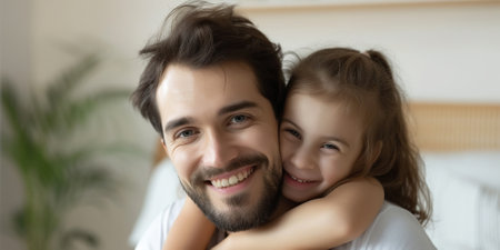 Man and his little daughter hugging in bedroomの素材