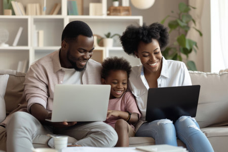 a Black family managing a home-based digital marketing agency, working on laptops and discussing strategiesの素材
