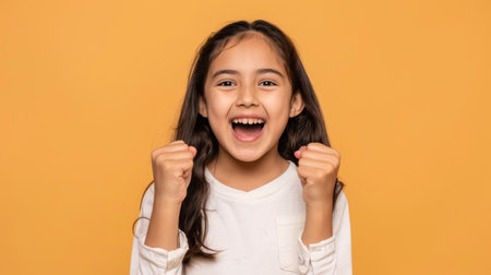 a Hispanic girl showing excitement on a beige studio backgroundの素材