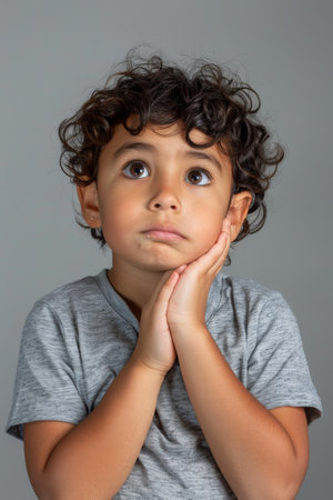 a Hispanic child feeling confused on a studio backgroundの素材