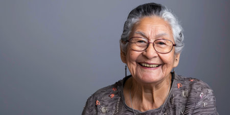 a Hispanic elderly person with a cheerful expression on a studio backgroundの素材