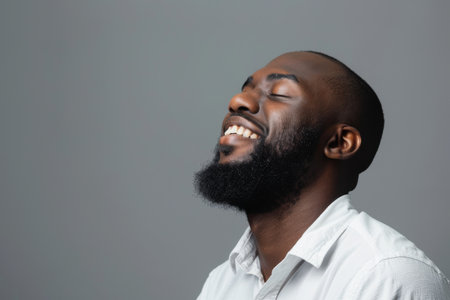an African American man expressing contentment on a studio backgroundの素材