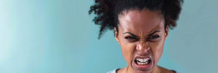 an African American woman expressing anger on a studio backgroundの素材