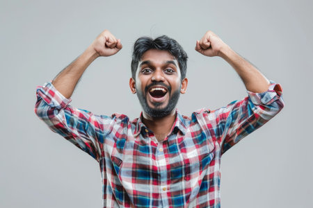 an Indian man showing excitement on a studio backgroundの素材