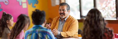 Teacher talking to students in classroom at school. Education concept.の素材