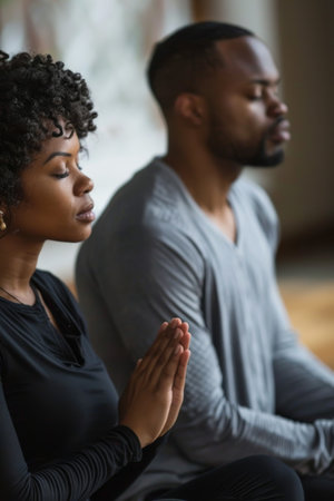 an African American couple engaging in a morning prayer or meditation session togetherの素材