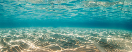 Underwater background with a sandy bottom and gently rolling waves above.の素材