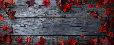 Canada Day background with a rustic wooden texture and scattered maple leaves.の素材