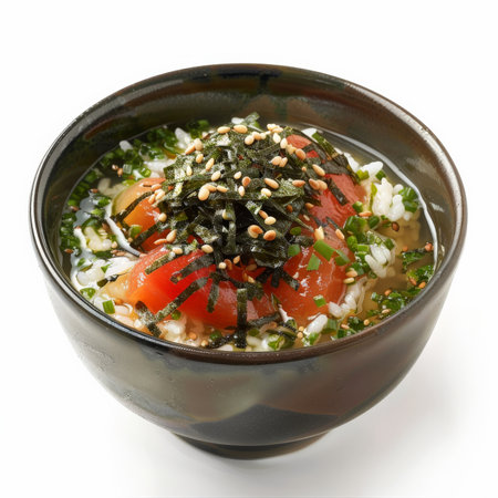 A bowl of ochazuke, rice with green tea broth, topped with umeboshi (pickled plum), nori strips, and sesame seeds, isolated on white background.の素材