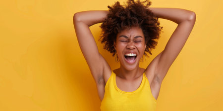 an African American woman showing excitement on a studio backgroundの素材