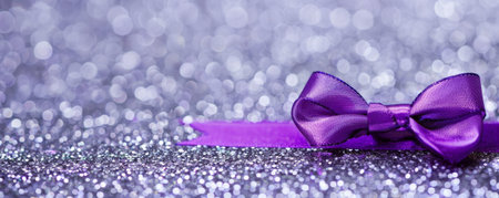 A vibrant purple ribbon bow on a silver glitter background. The bold color and shimmering texture create a striking and elegant look.の素材