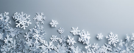 A cut-out paper banner with snowflake patterns, layered on a cool gray background, creating a wintery and serene visual.の素材
