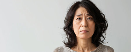 Unhappy middle-aged Japanese woman against a white background banner with copy space.ai generatedの素材