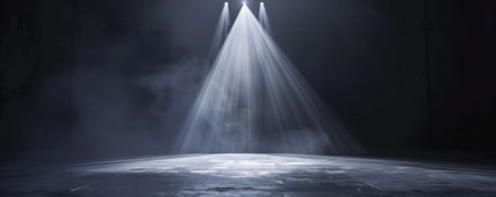 A dance stage with a single bright white spotlight in the center. The background is dark with subtle light beams, creating a dramatic and focused atmosphere.の素材