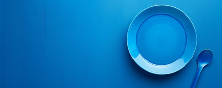 Festive scene featuring a blank blue plate on a blue table, viewed from above. The cool blue tones evoke a calm celebration. Space for text is included.の素材