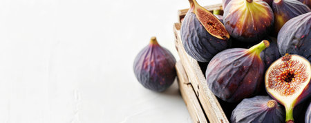 A wooden basket filled with fresh organic figs, with plenty of text space on a clean, white background.の素材