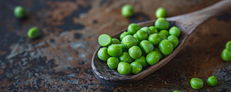 A close-up of a wooden spoon filled with peas, highlighting their round shape and green color against a rustic backdrop.の素材