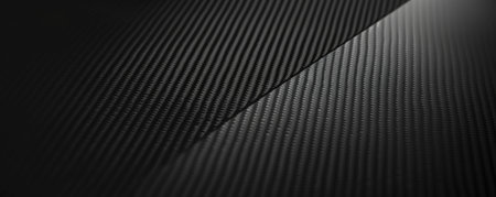 A dark black textured surface with a subtle, brushed appearance resembling carbon fiber. The texture adds a high-tech, premium feel to the background.の素材