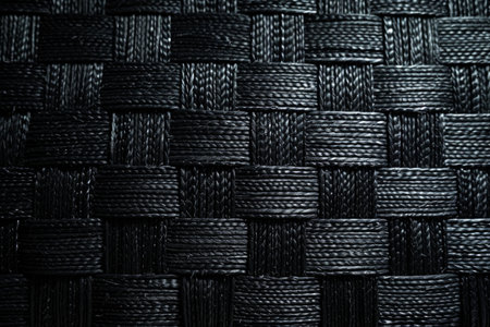 A dark black textured surface with a subtle, woven pattern, reminiscent of fabric. The texture adds depth and complexity to the dark background.の素材