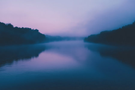 A serene, foggy river scene with a gradient sky shifting from soft lavender at the horizon to a deep, moody blue above. The river is obscured by mist, with its surface reflecting the gradient .jpgの素材