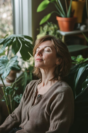 A middle-aged Caucasian woman relaxes in her cozy living room, surrounded by plants and warm decor, as she enjoys soothing music. Her eyes are closed, a serene smile on her face, embodying tranquility and joy as she lets the melodies wash over her.の素材