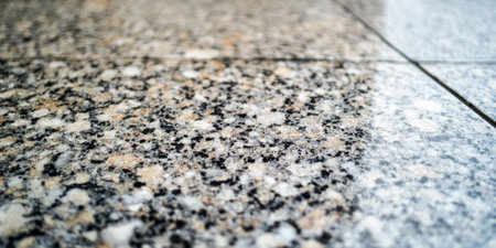 Smooth, polished granite texture with specks of silver, black, and cream, showing natural stone eleganceの素材