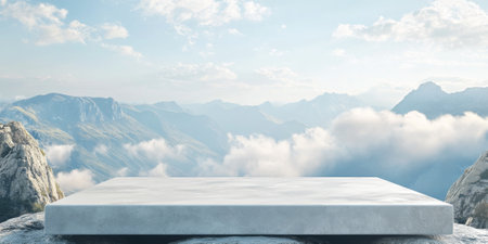 Outdoor stone podium in a serene mountain view with soft, white clouds, creating a minimal and natural setup for beauty product placementの素材