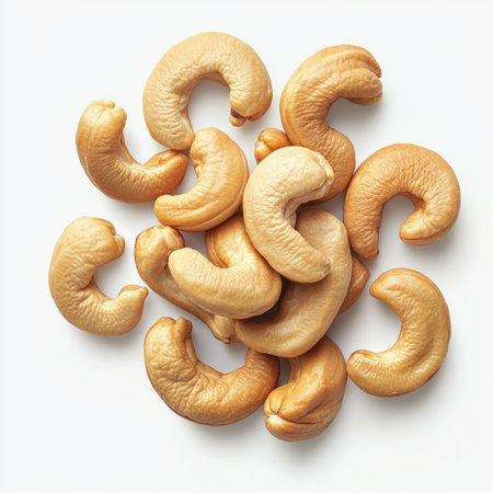 A handful of whole cashew nuts, isolated on a white background, showcasing a popular snackの素材