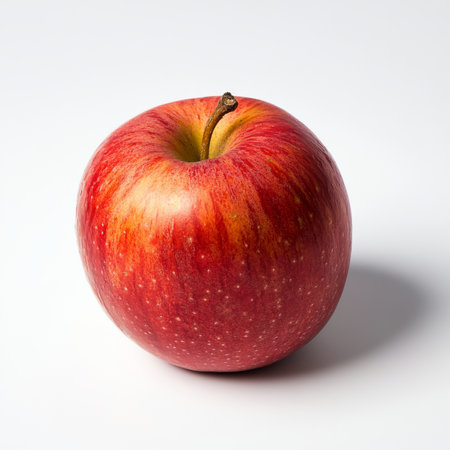 A single red apple with a shiny peel, isolated on a white background, highlighting a sweet and crisp fruit optionの素材