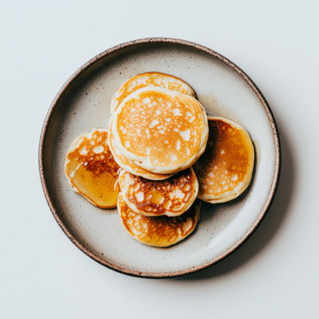 A plate of fluffy pancakes with syrup, isolated on a white background, showing a classic breakfastの素材