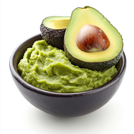 A bowl of mashed avocado, isolated on a white background, showing a fresh and creamy spreadの素材