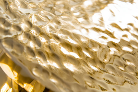 A hammered gold metal surface with uneven dents and a warm, luxurious shine.の素材