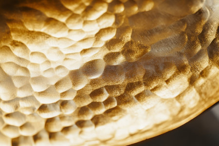 A hammered gold background with soft dents and a radiant reflective finish, adding a handcrafted touch.の素材
