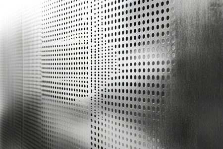 A perforated steel sheet with square holes and a clean, industrial aesthetic, ideal for tech-inspired designs.の素材