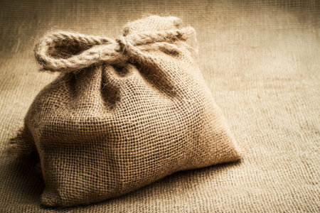 Rough burlap sack texture, coarse woven fibers in earthy brown tones, creating a rustic and natural feelの素材