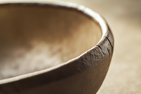 Textured smooth clay, earthy brown tones with visible natural grooves and soft reflections, rustic and calmingの素材