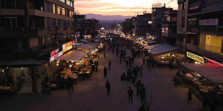 A bustling urban street market at dusk, with vibrant lights, food vendors, and people enjoying the lively atmosphere. The dynamic scene captures the energy of city life.の素材