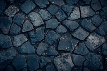 Textured cobblestone street, aged gray stones with visible weathering and irregular grooves, historic and tactileの素材