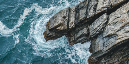 Ocean cliffside rock background with rugged, weathered gray stones shaped by crashing waves.の素材