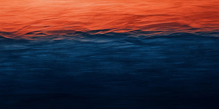 A textured burnt orange abstract background merging with deep navy blue, resembling a warm sunset over the ocean.の素材