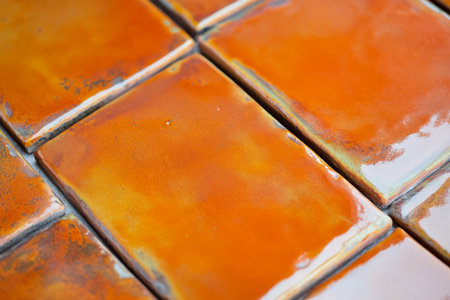 Macro shot of burnt orange ceramic tile, with a glazed finish and subtle texture that gives an earthy, artisanal look.の素材