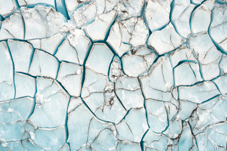 Cracked ice patterns, forming intricate natural lines in shades of light blue and silver.の素材