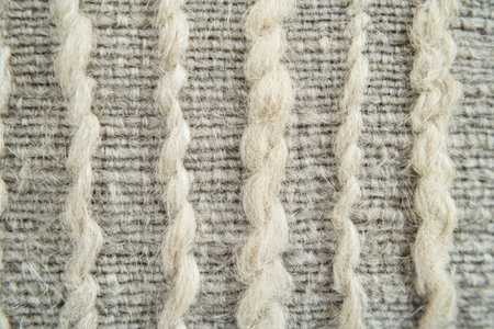 Macro shot of handwoven Himalayan wool fabric, soft gray with visible twisted fibers and artisanal texture.の素材