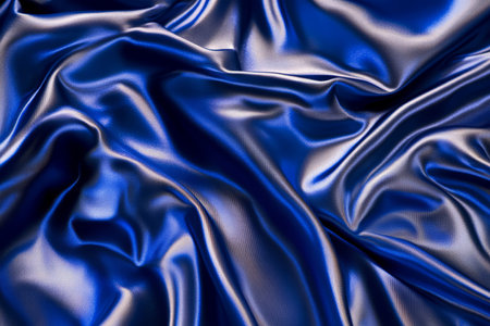 A visually striking fabric texture background with a silky, iridescent satin surface. The shimmering reflections in royal blue and silver create a dynamic, elegant composition, emphasizing the smooth, flowing folds of the high-quality textile.の素材